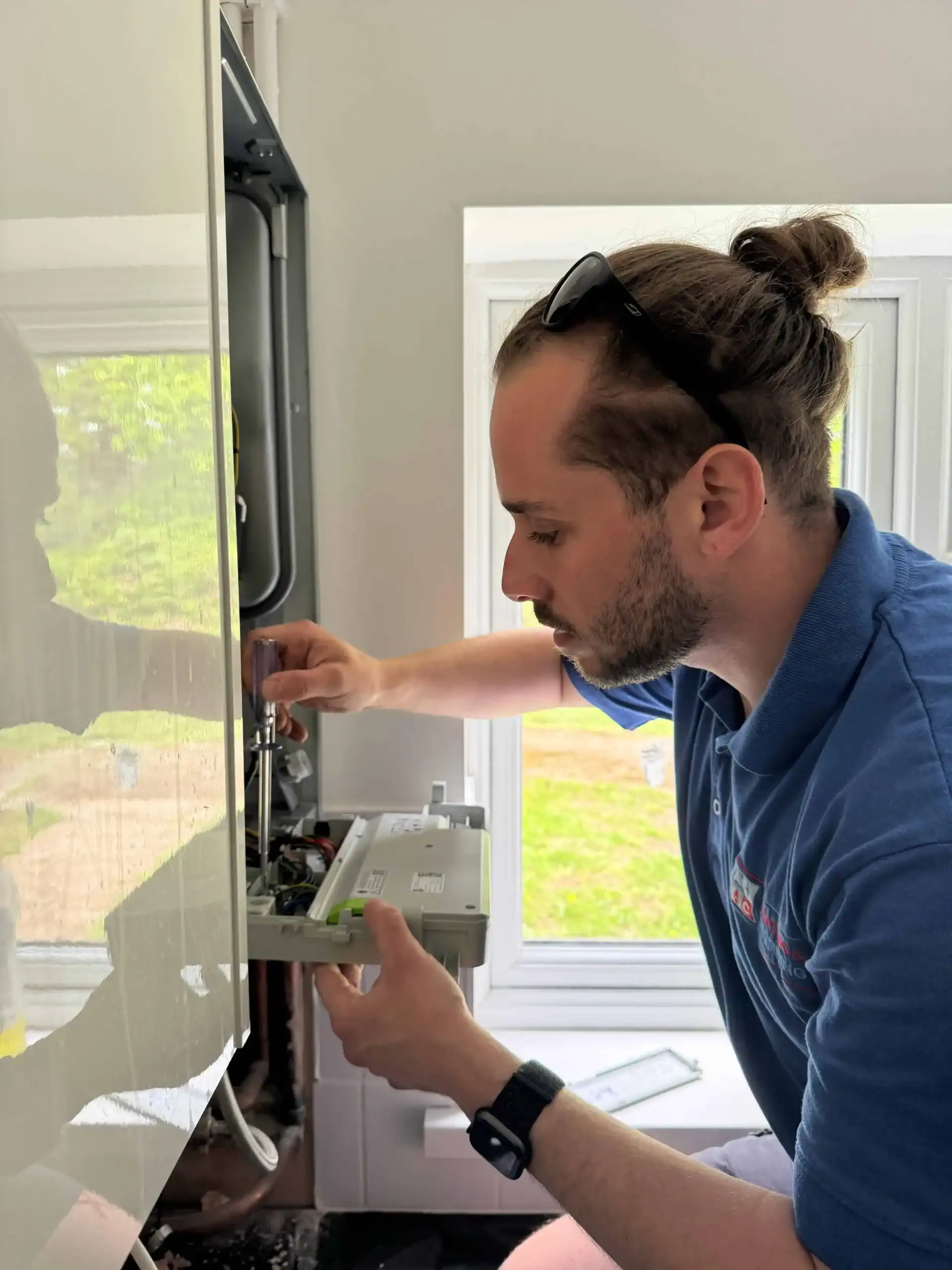water-heater-repair-in-barnet Plumber repairing electric water heater in utility room